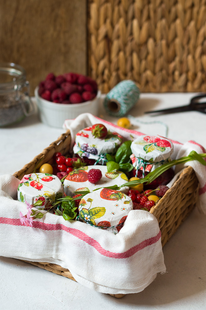 Basket full of chia seed jams in jars with berries