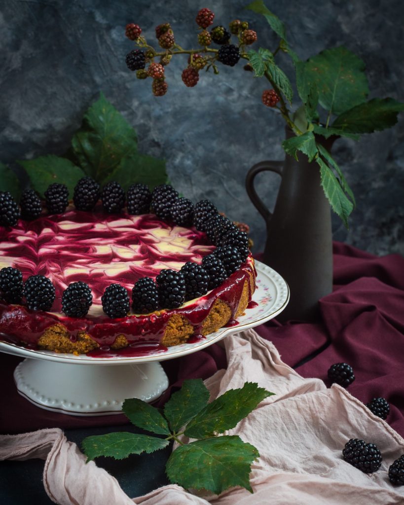 blackberry swirled cheesecake on cake stand