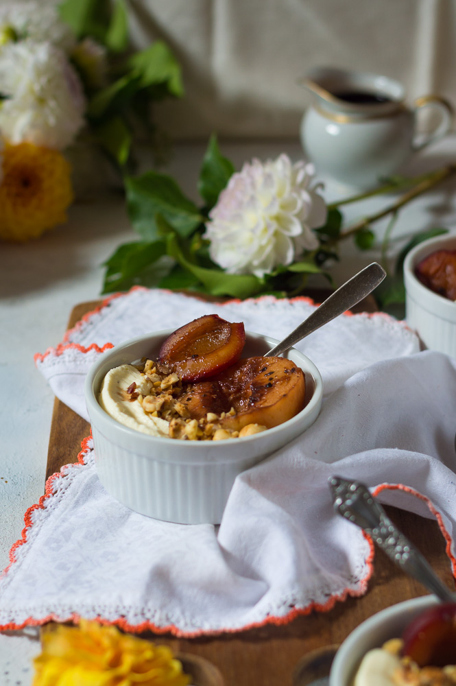 Bowl of poached peaches and plums in marsala wine with mascarpone cream and chopped hazelnuts