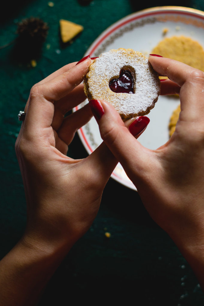 A woman hands assembling Linzer Christmas cookies