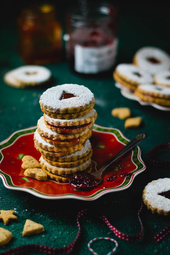 Stack of Christmas Linzer cookies on festive plate