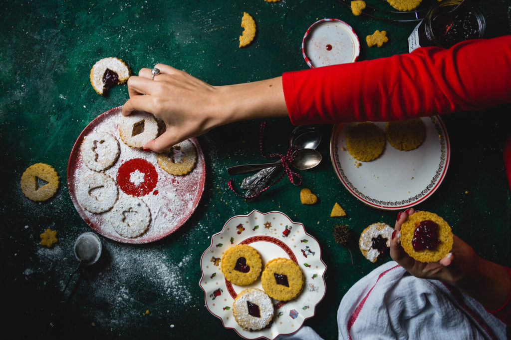 Woman hand reaching for linzer cookie