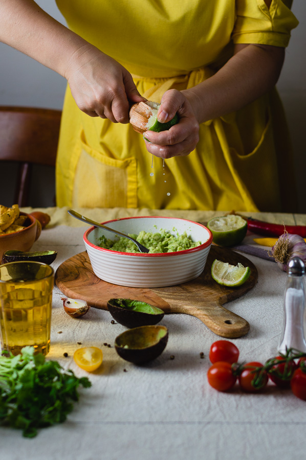 A woman juicing fresh limes for making guacamole dip