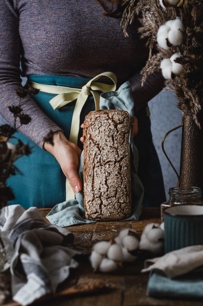 woman holding a freshly baked rye sourdough bread