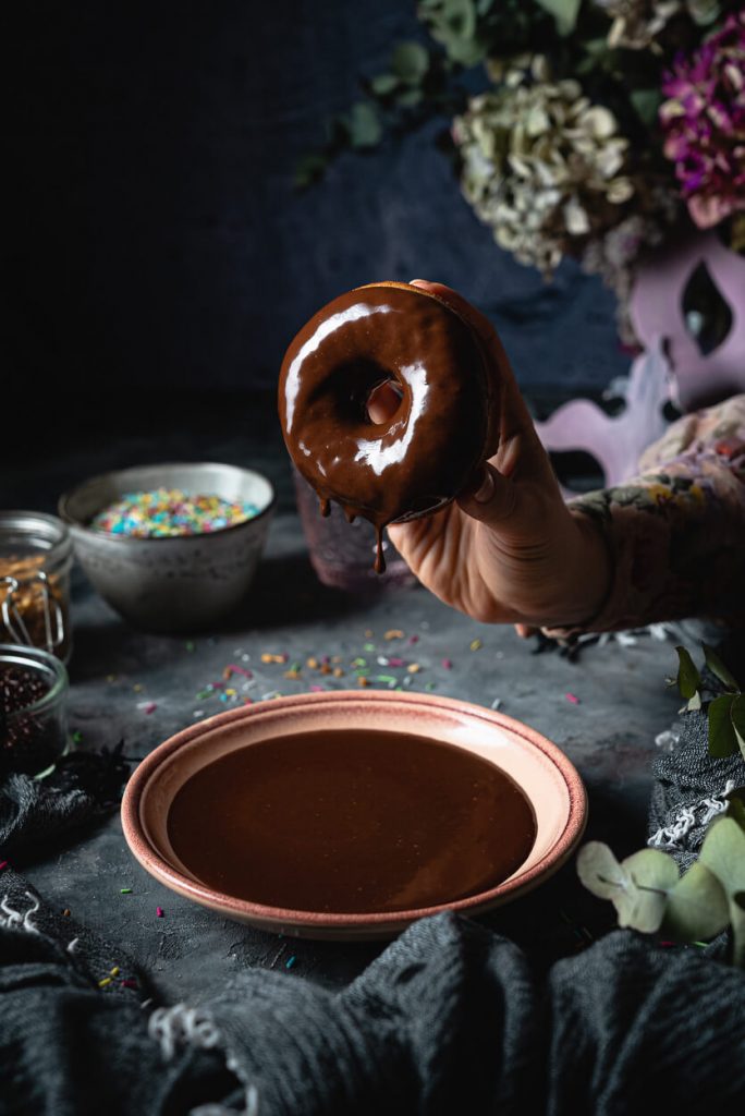 dipping donut in chocolate glaze