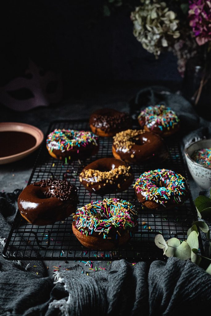 chocolate glazed yeast donuts sprinkled with rainbow sprinkles