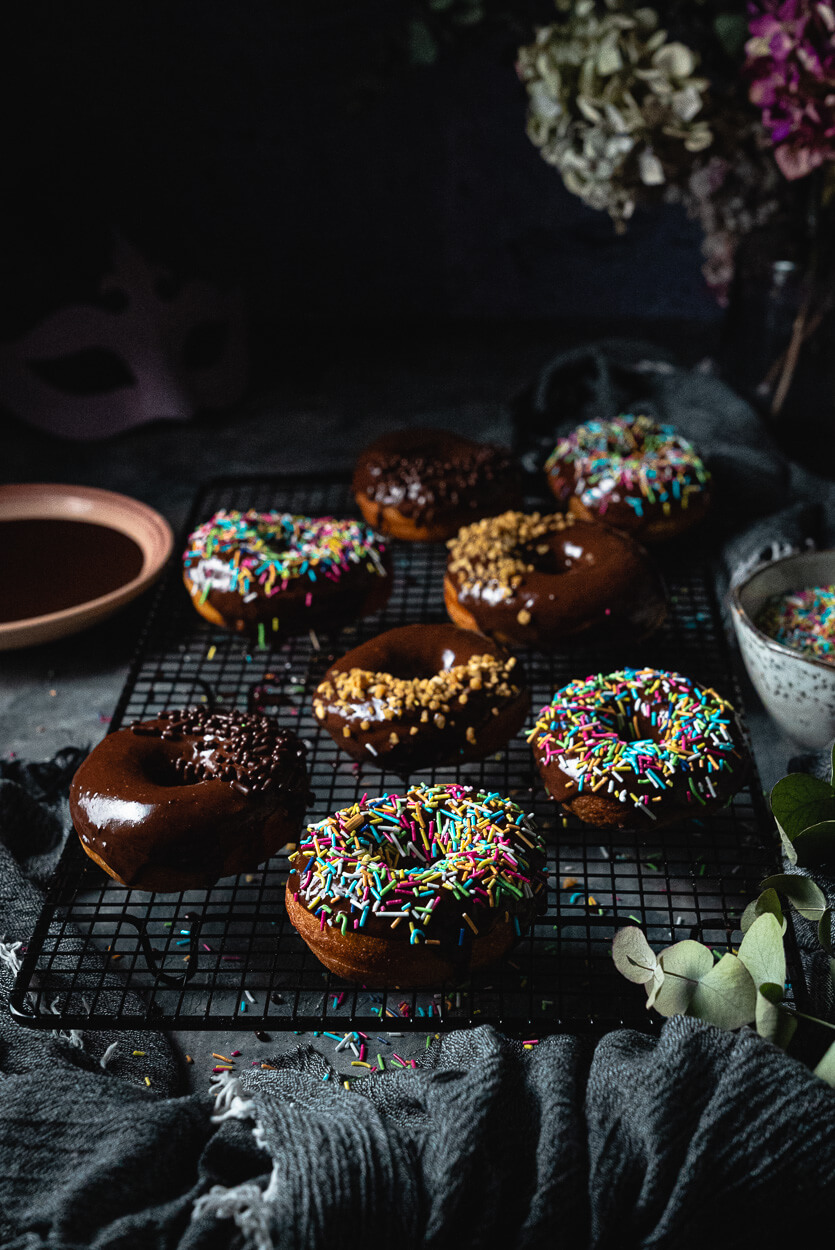 chocolate glazed yeast donuts sprinkled with rainbow sprinkles