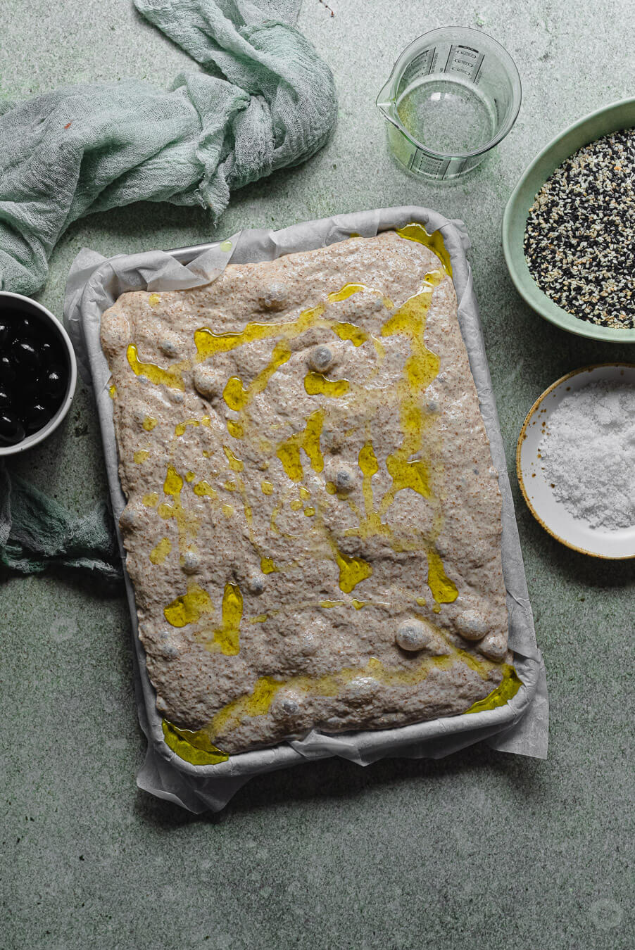 whole wheat focaccia dough after cold fermentation, drizzled with olive oil