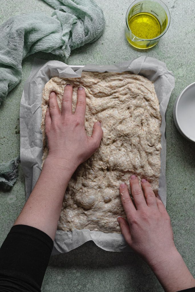 stretching focaccia dough with the fingers