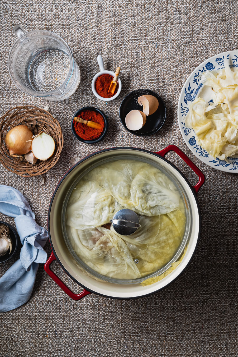 sarma cababge rols covered with a lid in order to prevent unwrapping the rolls during the cooking process