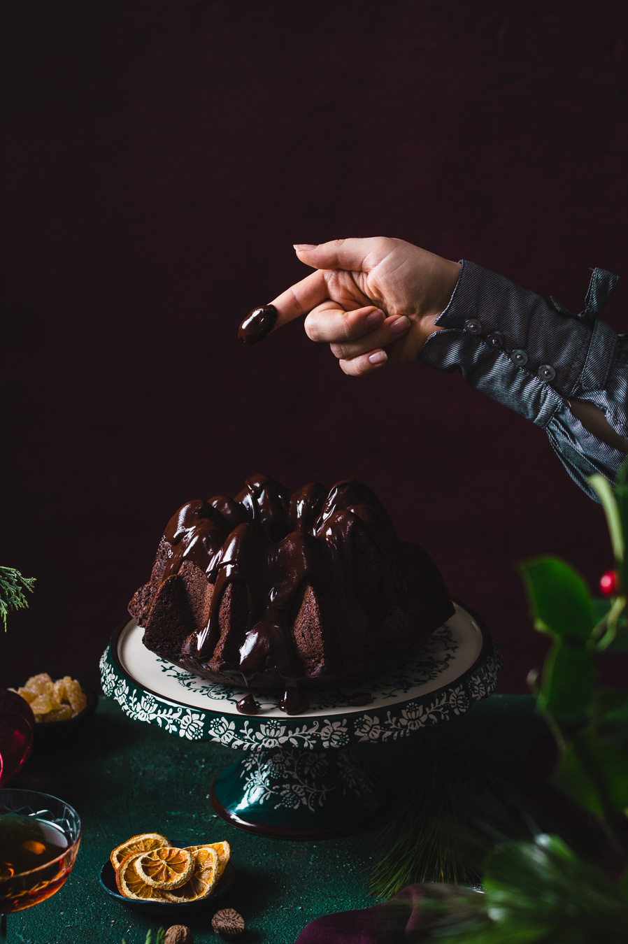 woman's finger covered in dark chocolate ganache