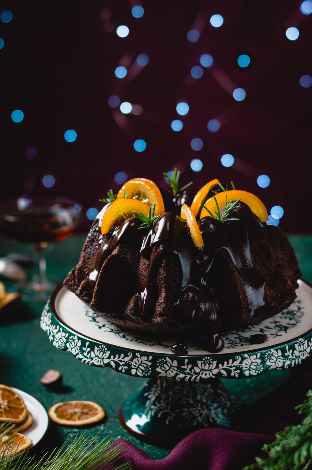carob and bundt cake covered in chocolate ganache and decorated with candied orange slices
