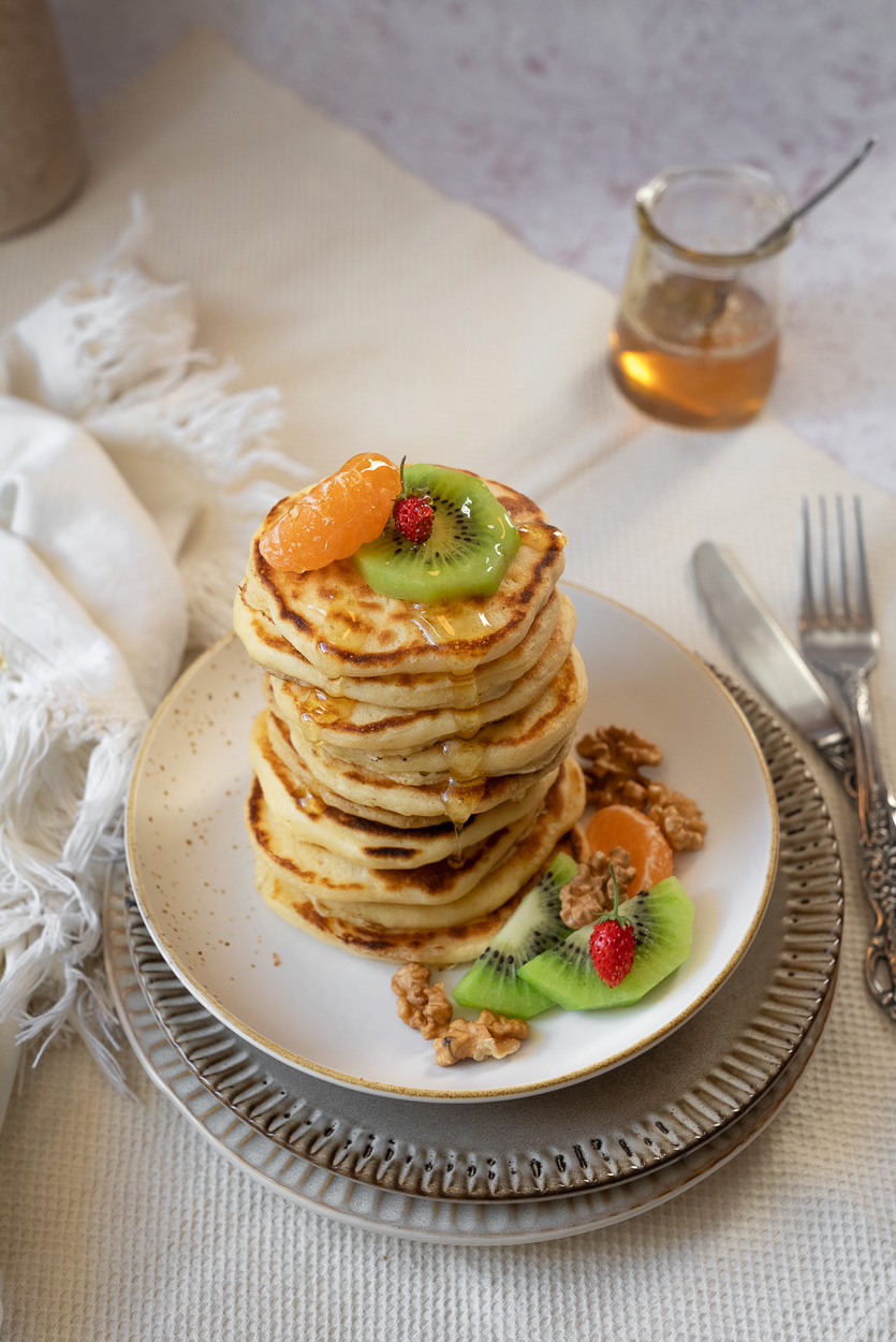 kefir pancakes served with fresh fruit, honey and walnuts