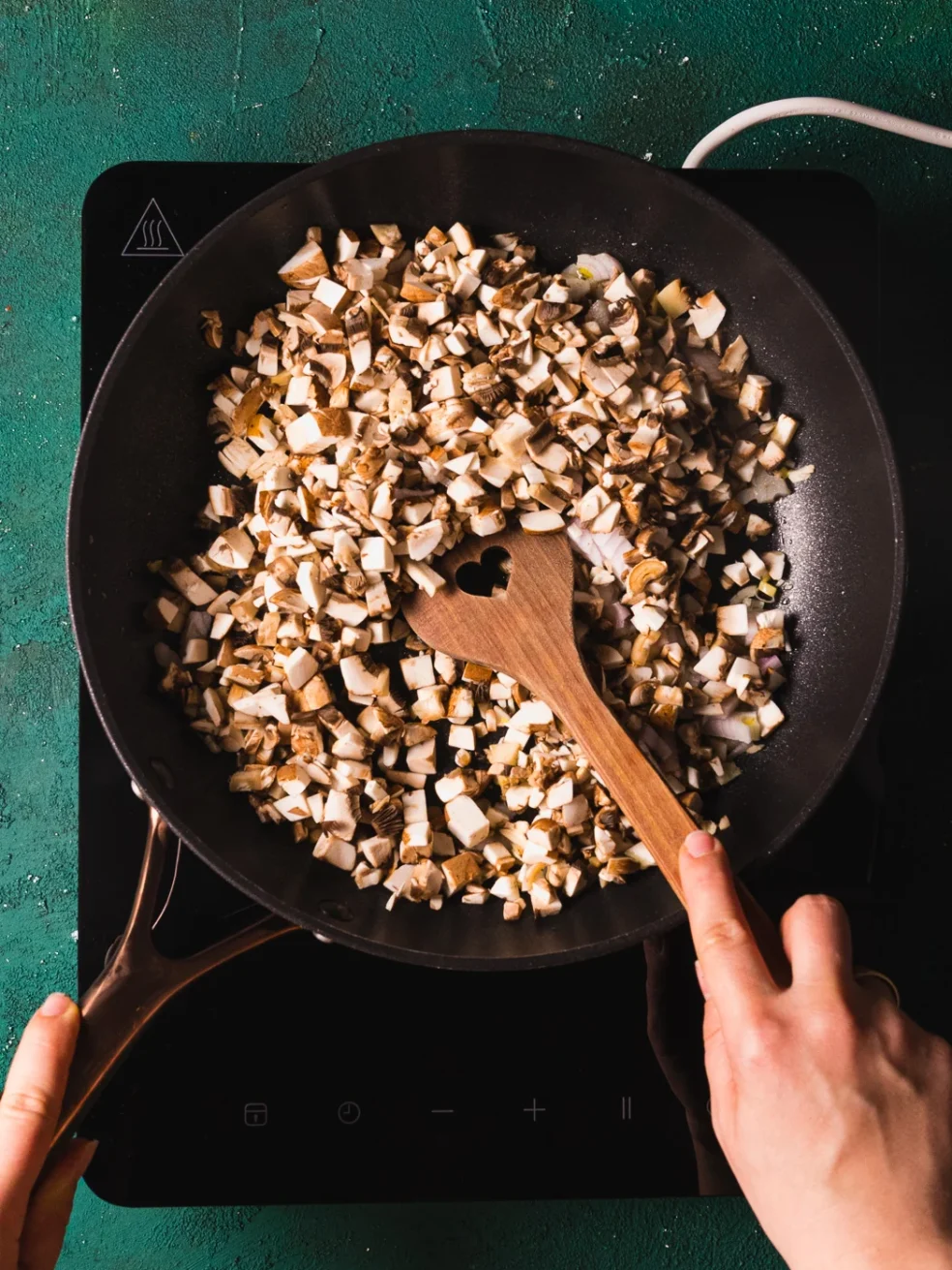 sauteeing onions and cremini mushrooms in the pan