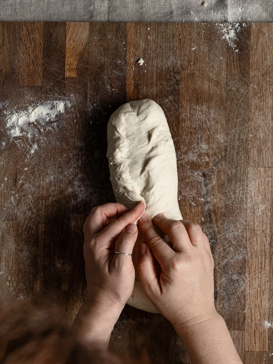 shaping bread dough into a loaf
