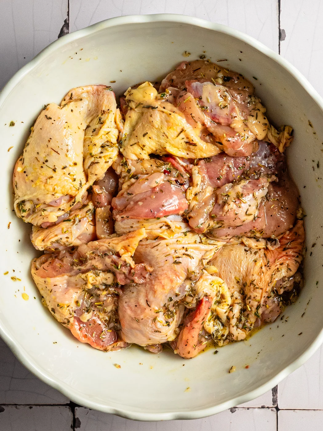 deboned chicken thighs being marinated in herbes de provence marinade