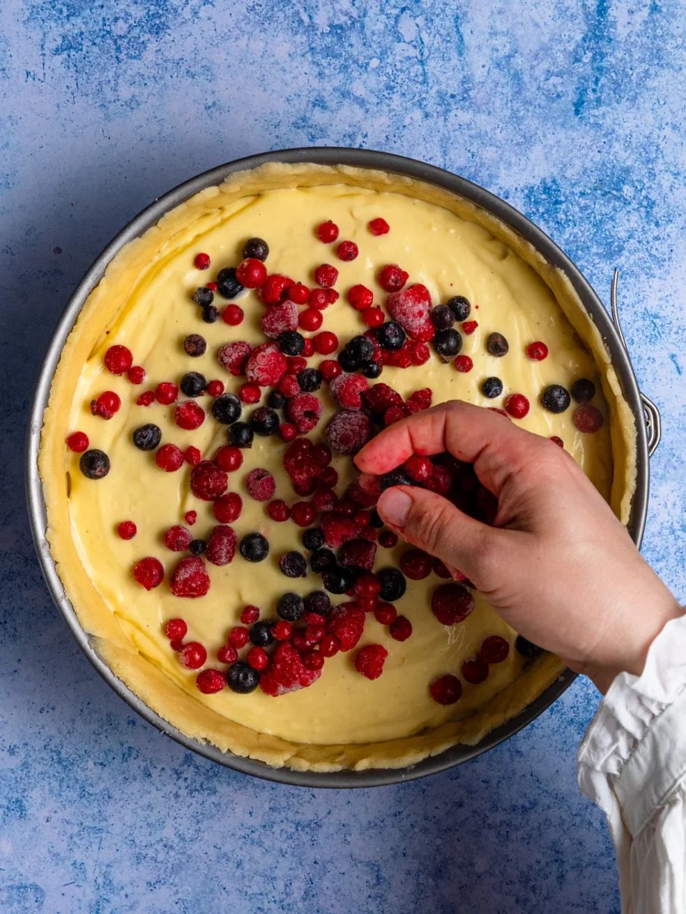 adding berries to a mileram cake