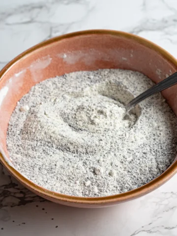 adding dry ingredients to a bowl