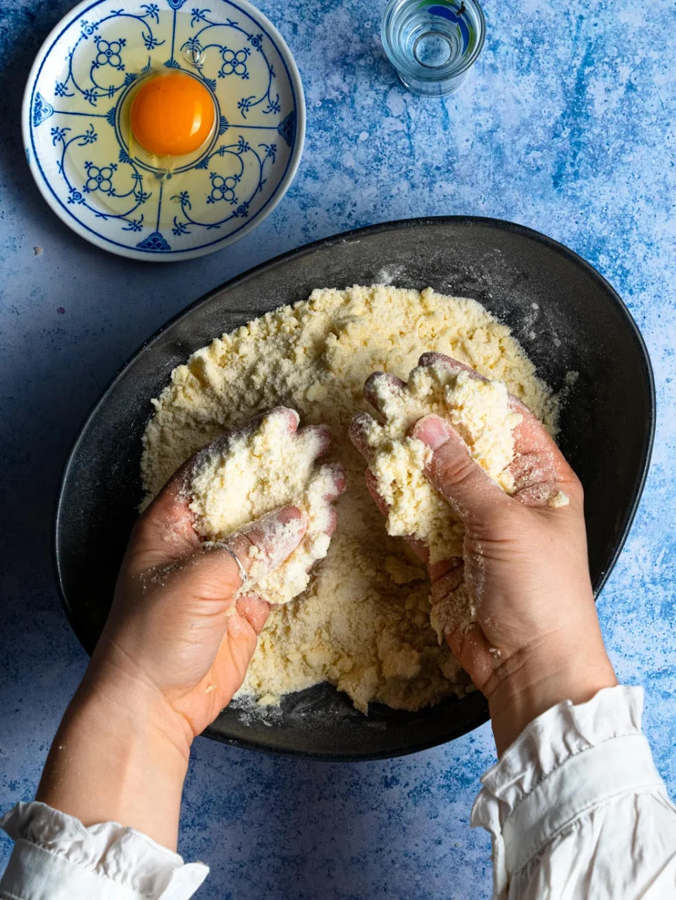 rubbing dry ingredients with cold butter to form shortcrust pastry