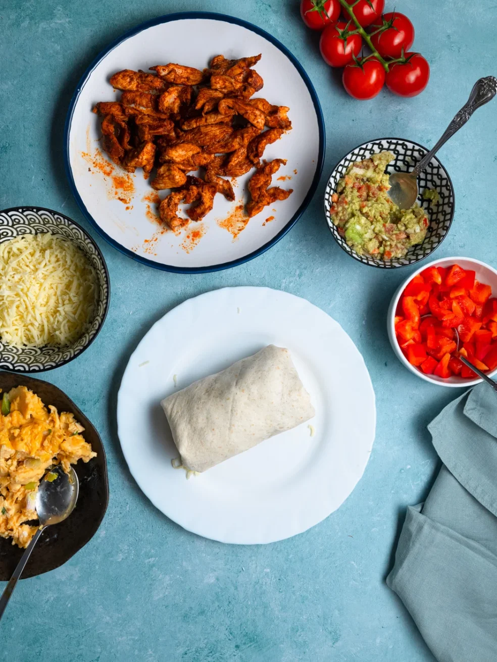 wrapped chicken breakfast burrito on a white plate, before toasting