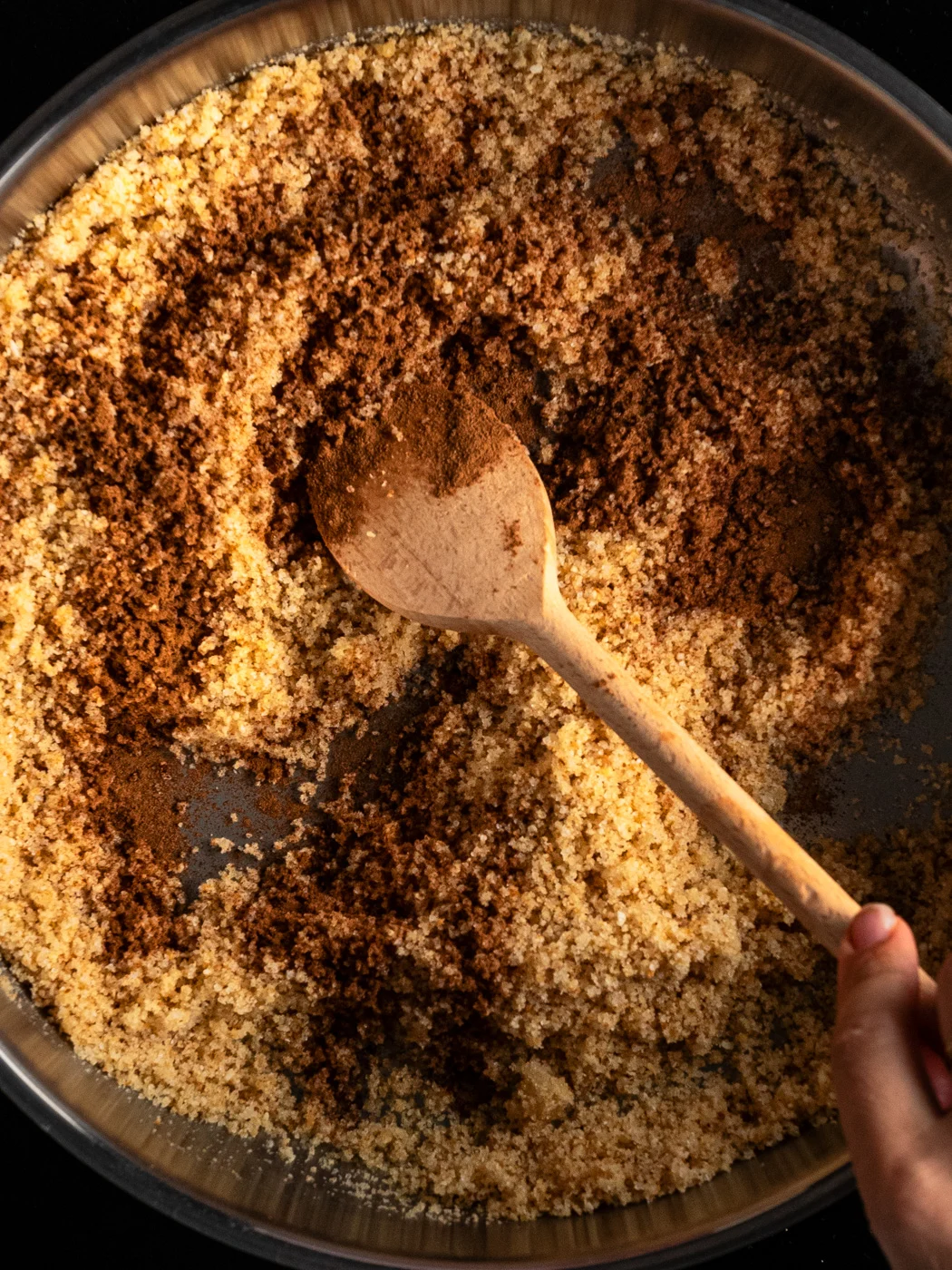 mixing all ingredients in a large skillet to make breadcrumbs coating for plum dumplings