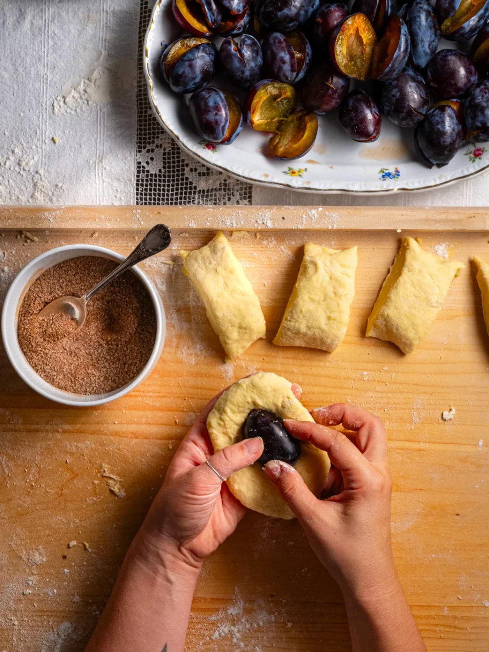 adding the plum into a piece of potato dough